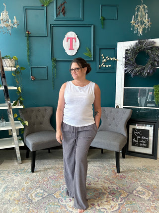 Woman standing in a room with teal walls, gray chairs, and decorative elements.