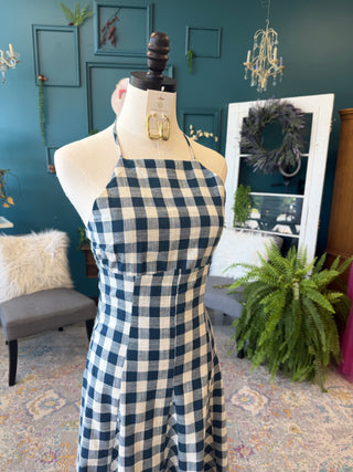 Mannequin wearing a blue and white checkered dress in a room with decorative elements.
